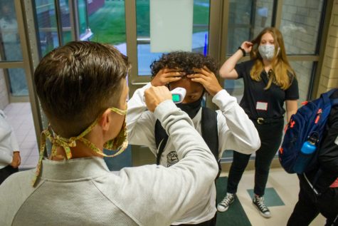 World Language teacher Jacob Dueck takes the temperature of an incoming freshman as he arrives for orientation day.Collin Nawrocki - The Phoenix